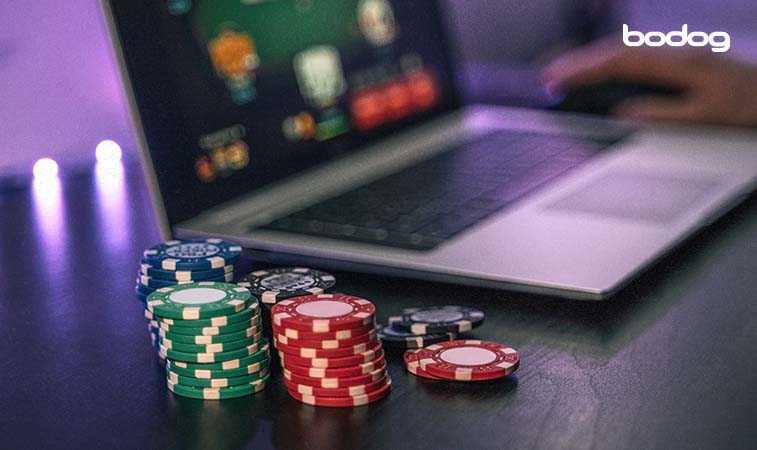 fichas de poker junto a una laptop