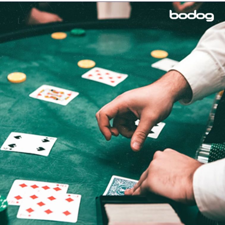 dealer levantando carta en mesa de casino