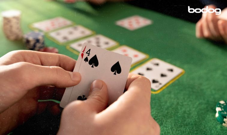 jugador de poker con dos cartas en mano